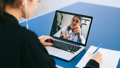 Business professionals participating in a video conference meeting with laptops and screens