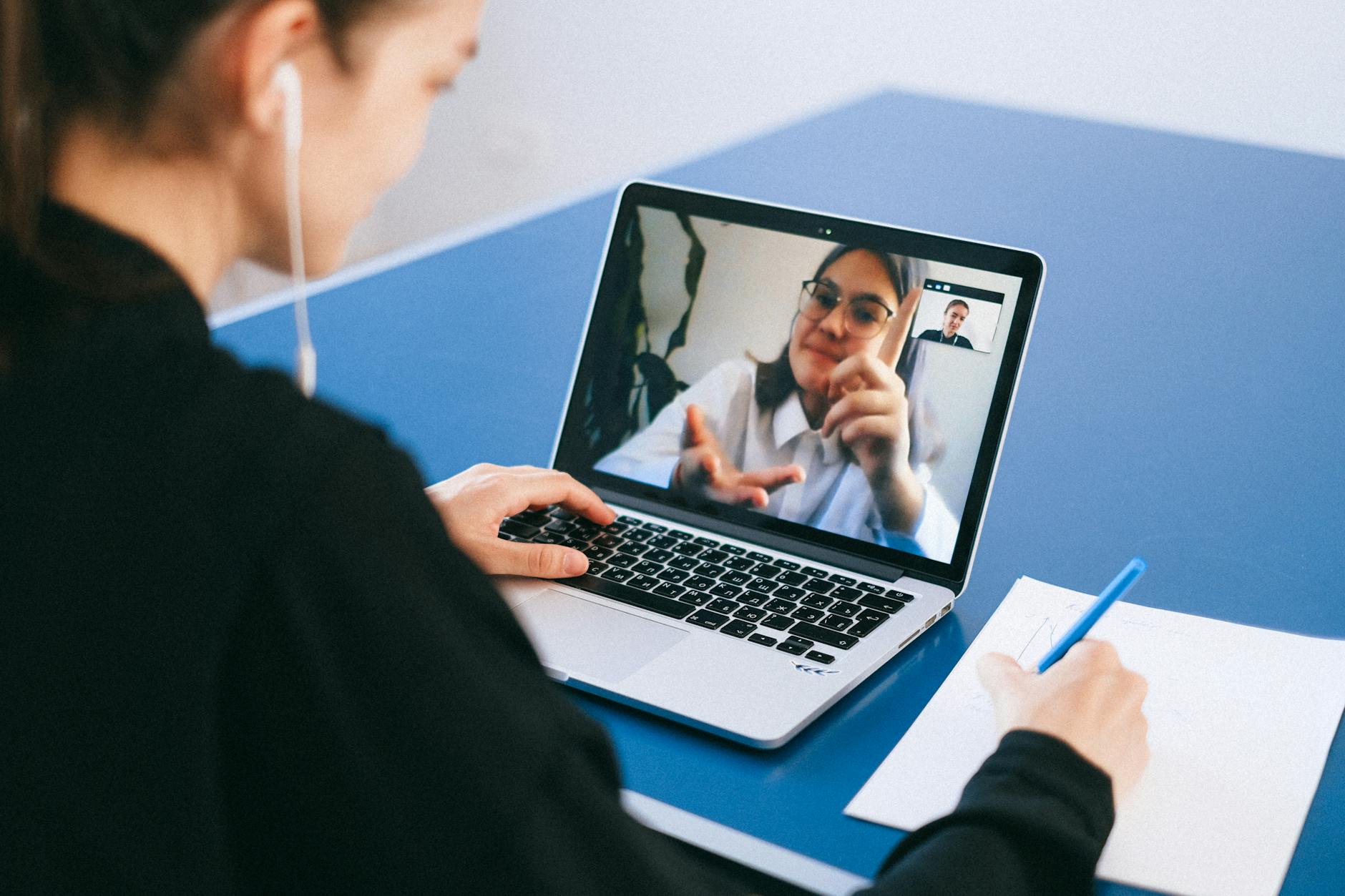 Business professionals participating in a video conference meeting with laptops and screens
