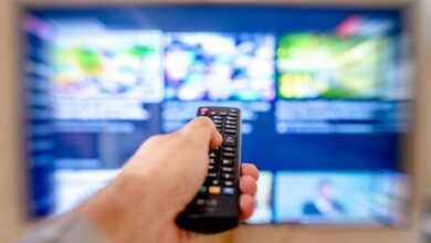 Modern television displaying streaming service interface with remote control