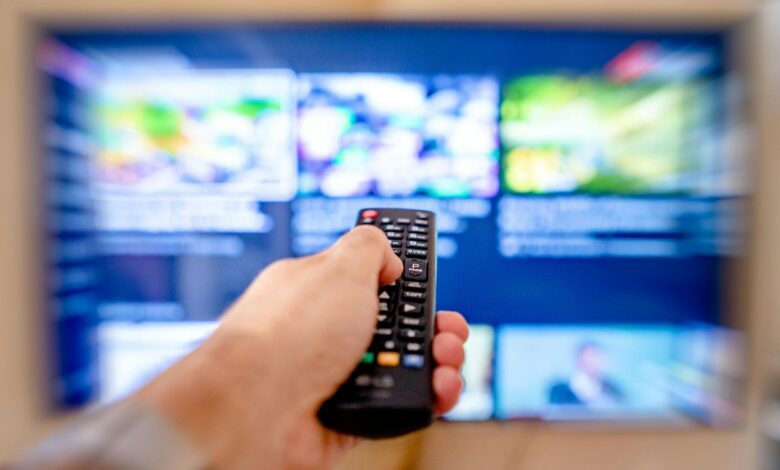 Modern television displaying streaming service interface with remote control