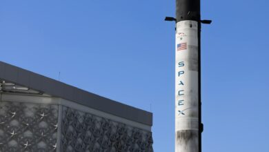 Rocket launching into blue sky with white clouds and exhaust trail