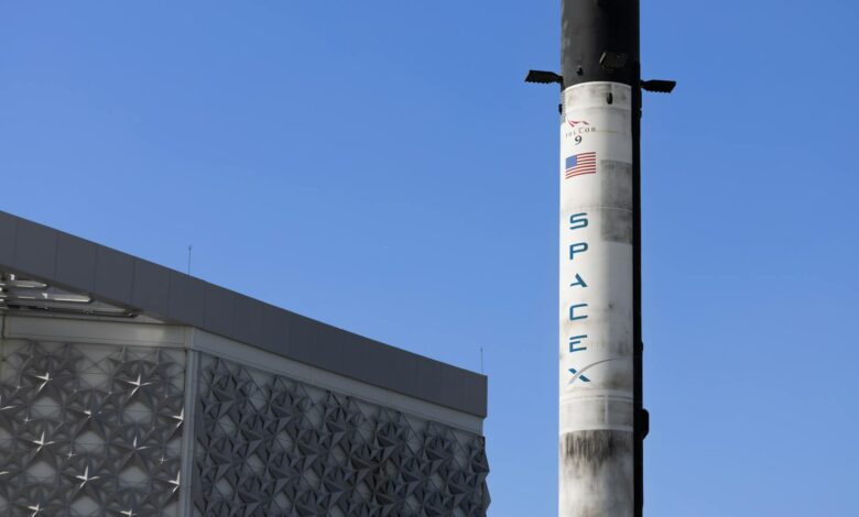 Rocket launching into blue sky with white clouds and exhaust trail