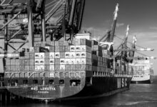 Large container ship loaded with colorful shipping containers on water