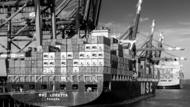Large container ship loaded with colorful shipping containers on water