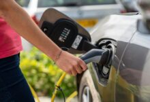 Electric vehicle charging station with charging cable connected to car