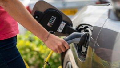 Electric vehicle charging station with charging cable connected to car