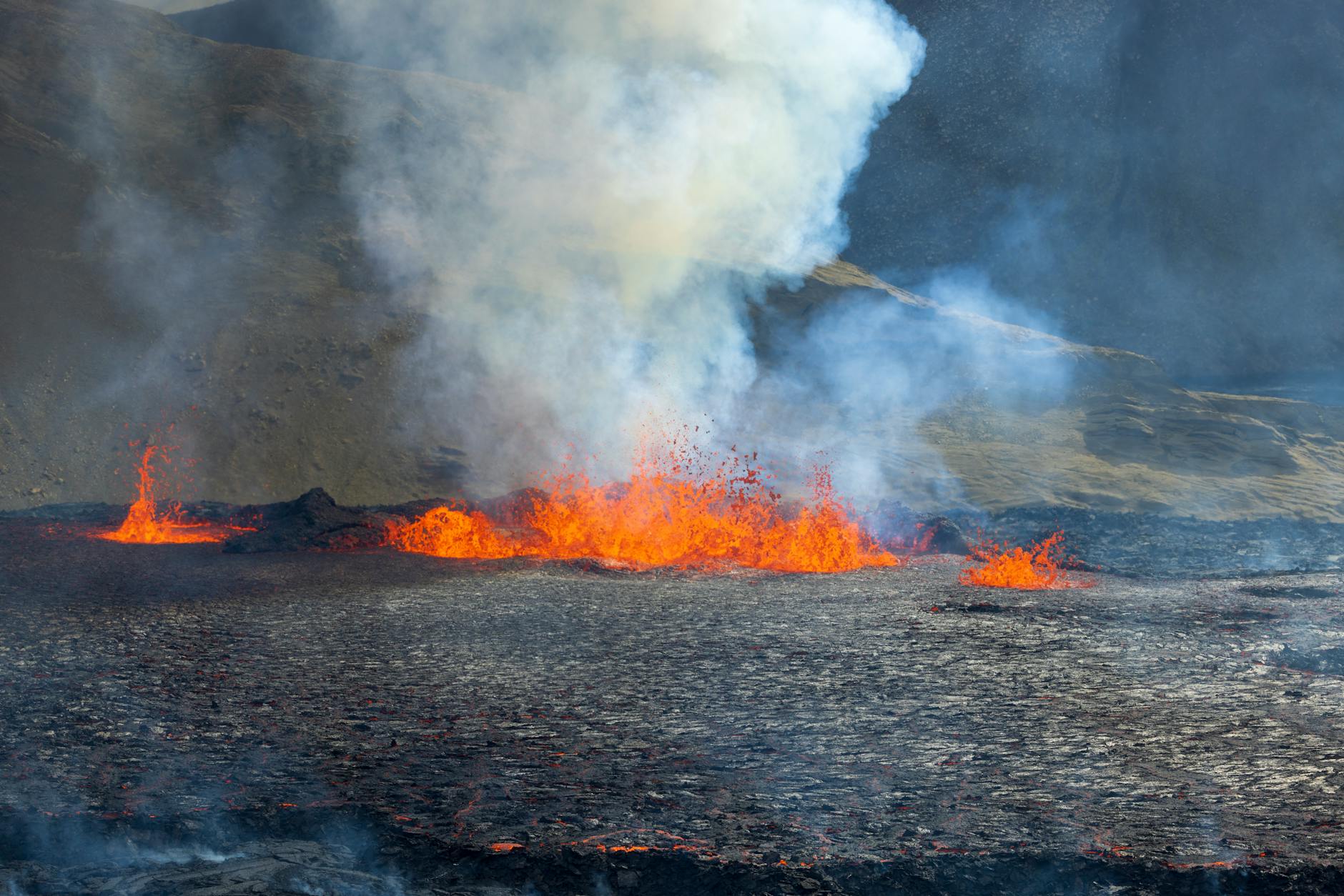 Dramatic volcanic eruption with ash plume rising into dark sky