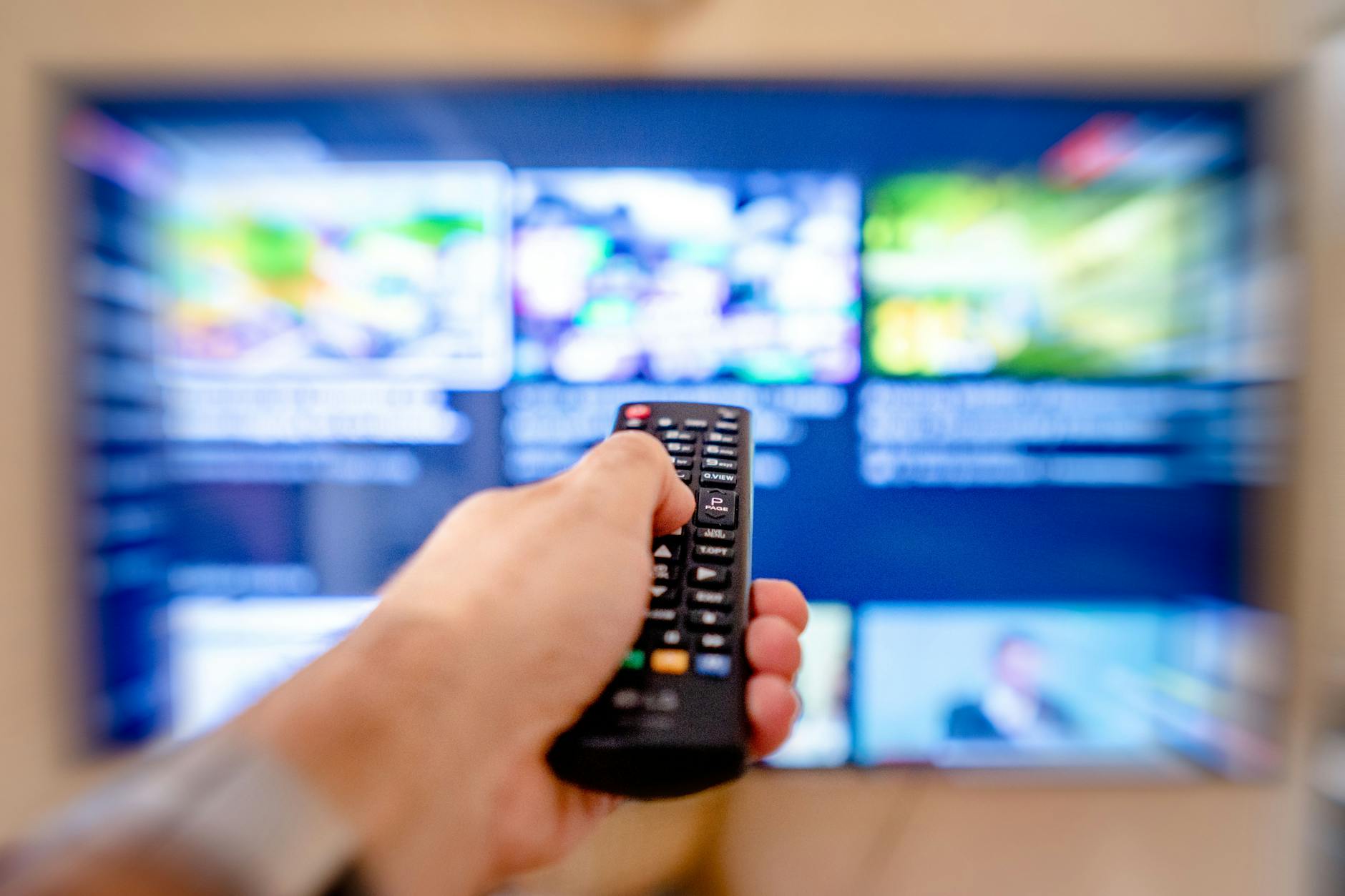 Person watching streaming content on a television screen in a modern living room