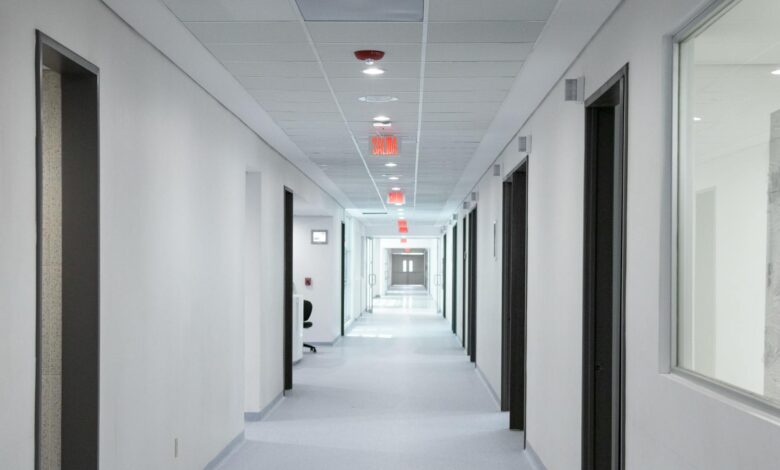 Empty hospital corridor with medical equipment and patient rooms