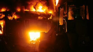 Large industrial fire with flames and smoke rising into the sky