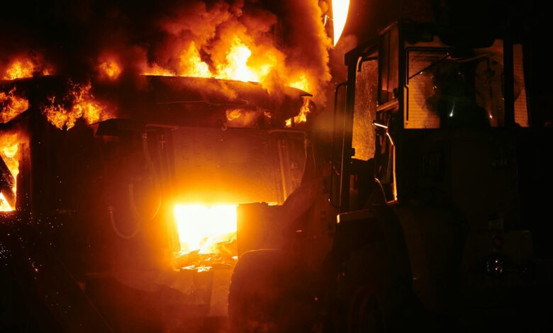 Large industrial fire with flames and smoke rising into the sky