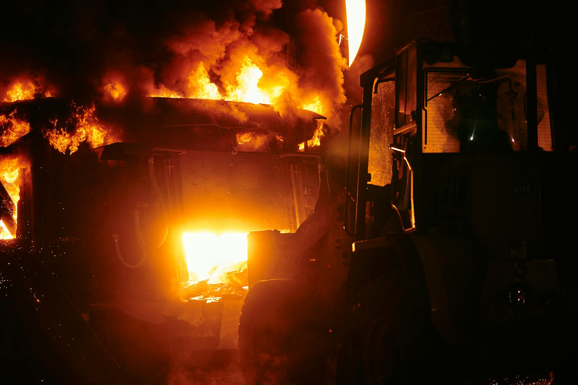 Large industrial fire with flames and smoke rising into the sky
