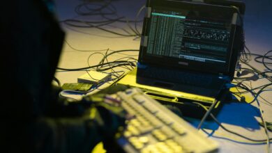 Cybersecurity professional monitoring network security systems on multiple computer screens