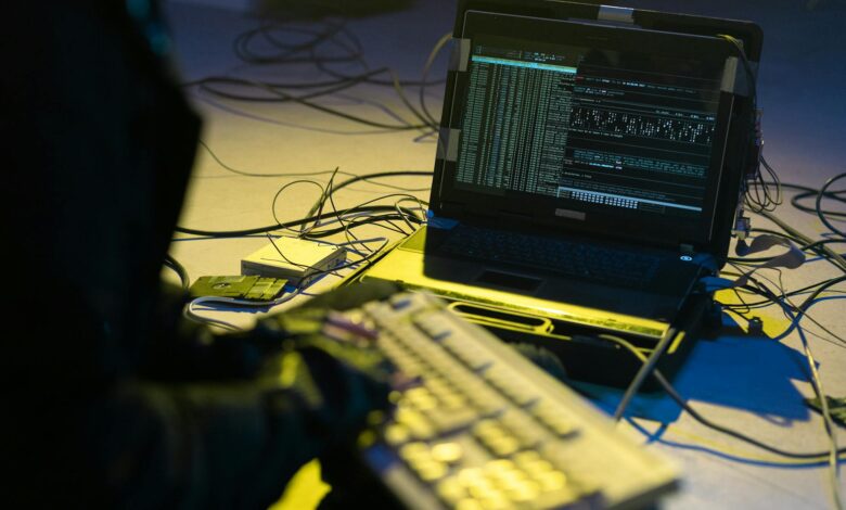 Cybersecurity professional monitoring network security systems on multiple computer screens