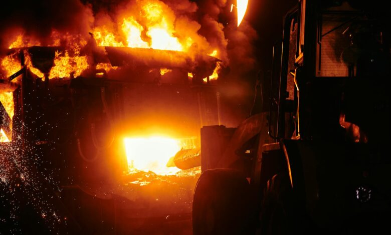 Large industrial fire with thick black smoke rising into the sky