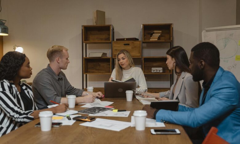 Business professionals collaborating in modern office environment with computers and communication tools