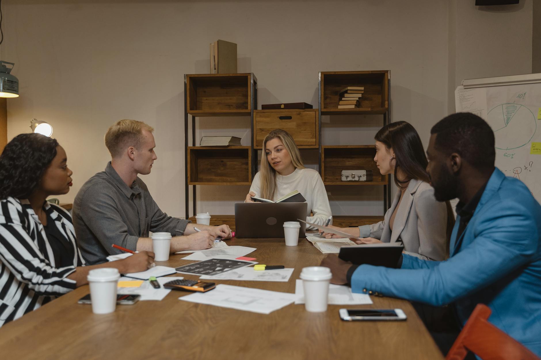 Business professionals collaborating in modern office environment with computers and communication tools