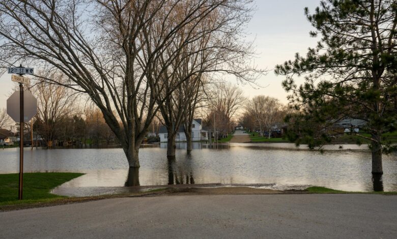 Aerial view of flooded residential area with houses partially submerged in muddy water