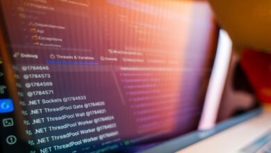 Multiple computer monitors displaying banking system interfaces and security alerts