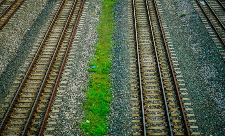 Railroad tracks stretching into the distance through rural landscape
