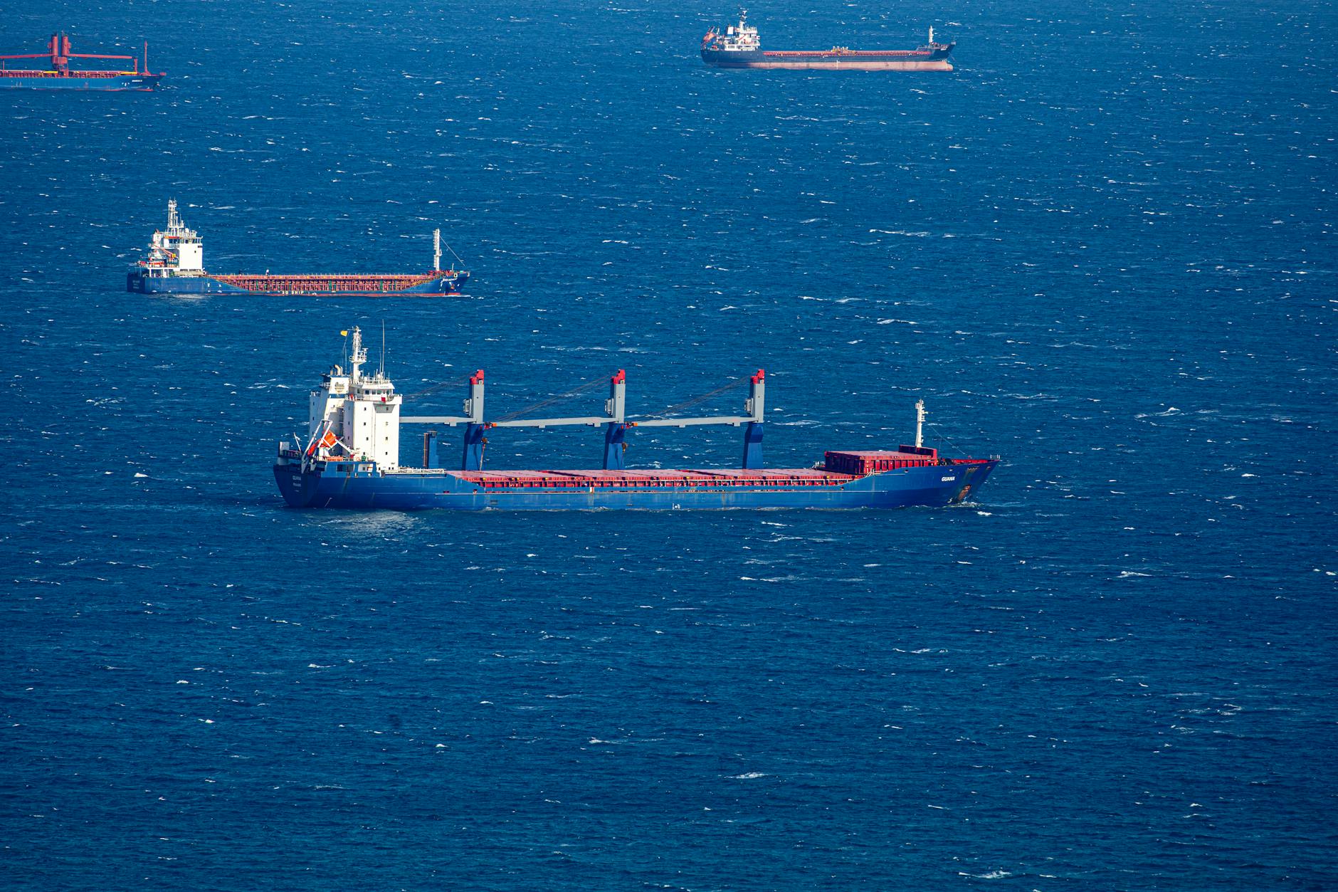 Large cargo ships navigating through a busy maritime shipping channel