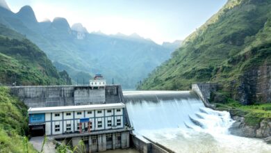 Large hydroelectric dam structure with water flowing through spillways