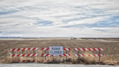 Empty highway with road closure barriers and warning signs blocking traffic