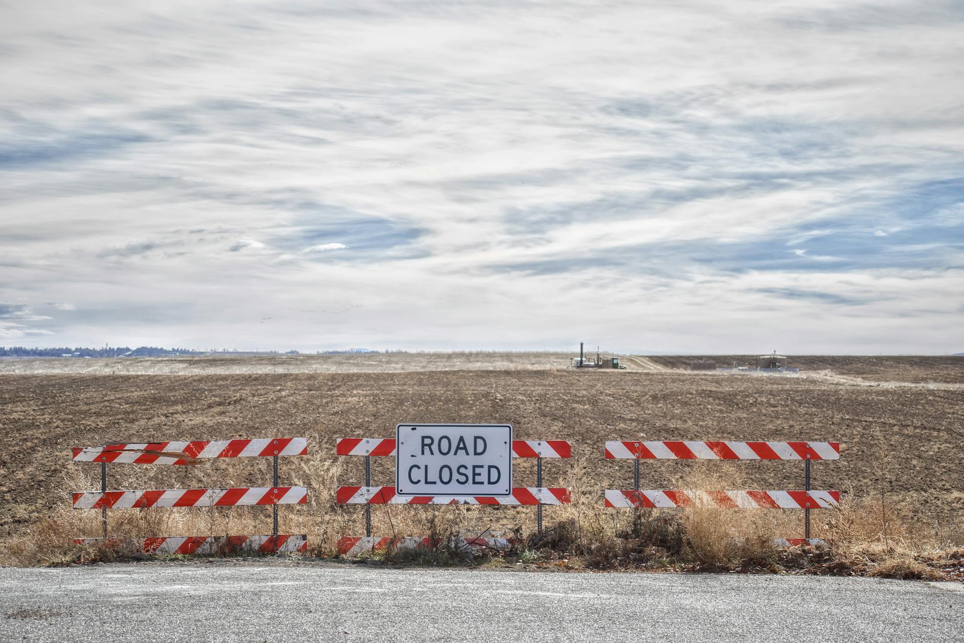 Empty highway with road closure barriers and warning signs blocking traffic
