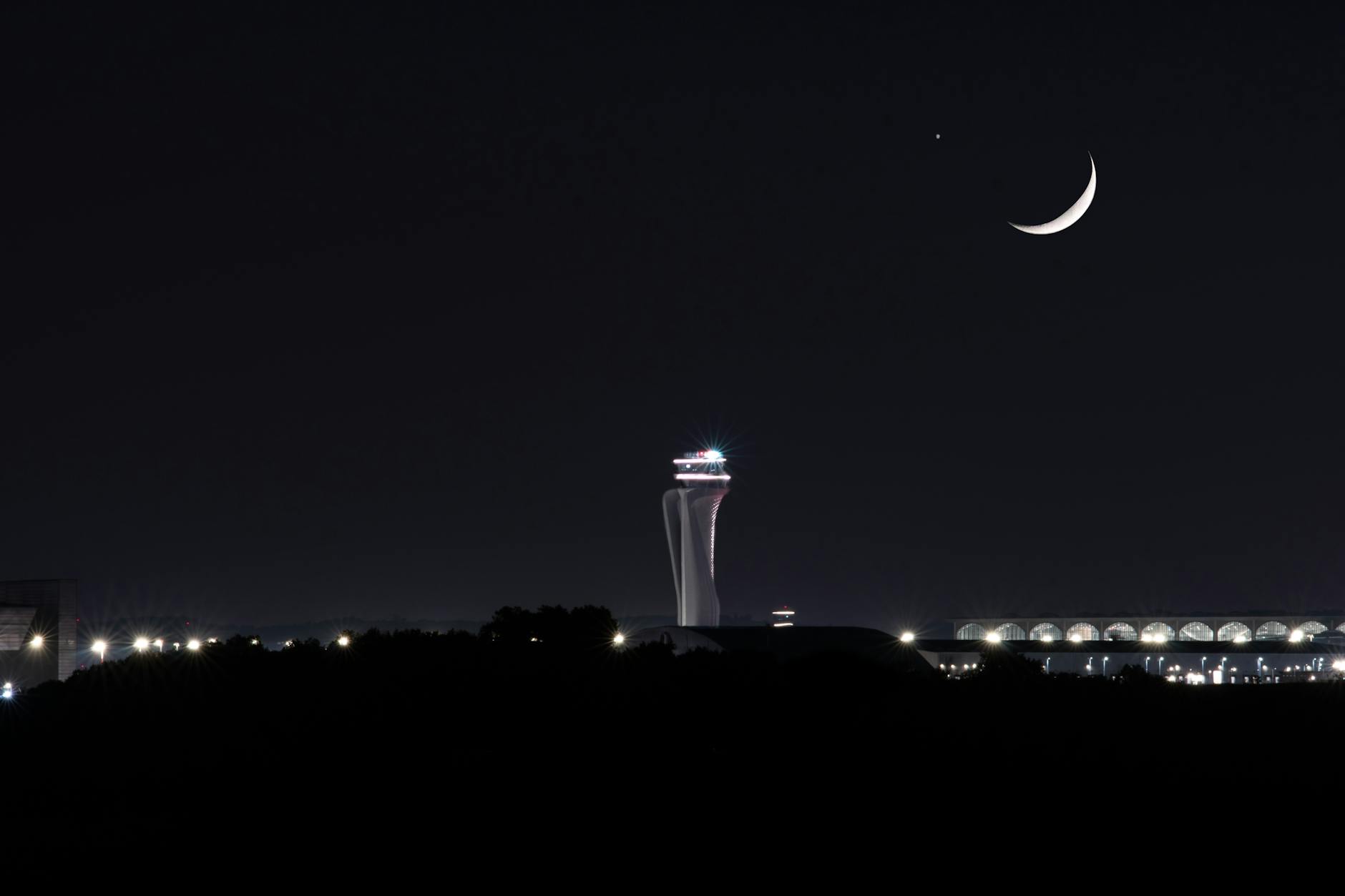Air traffic control tower at major airport overlooking runway and aircraft operations