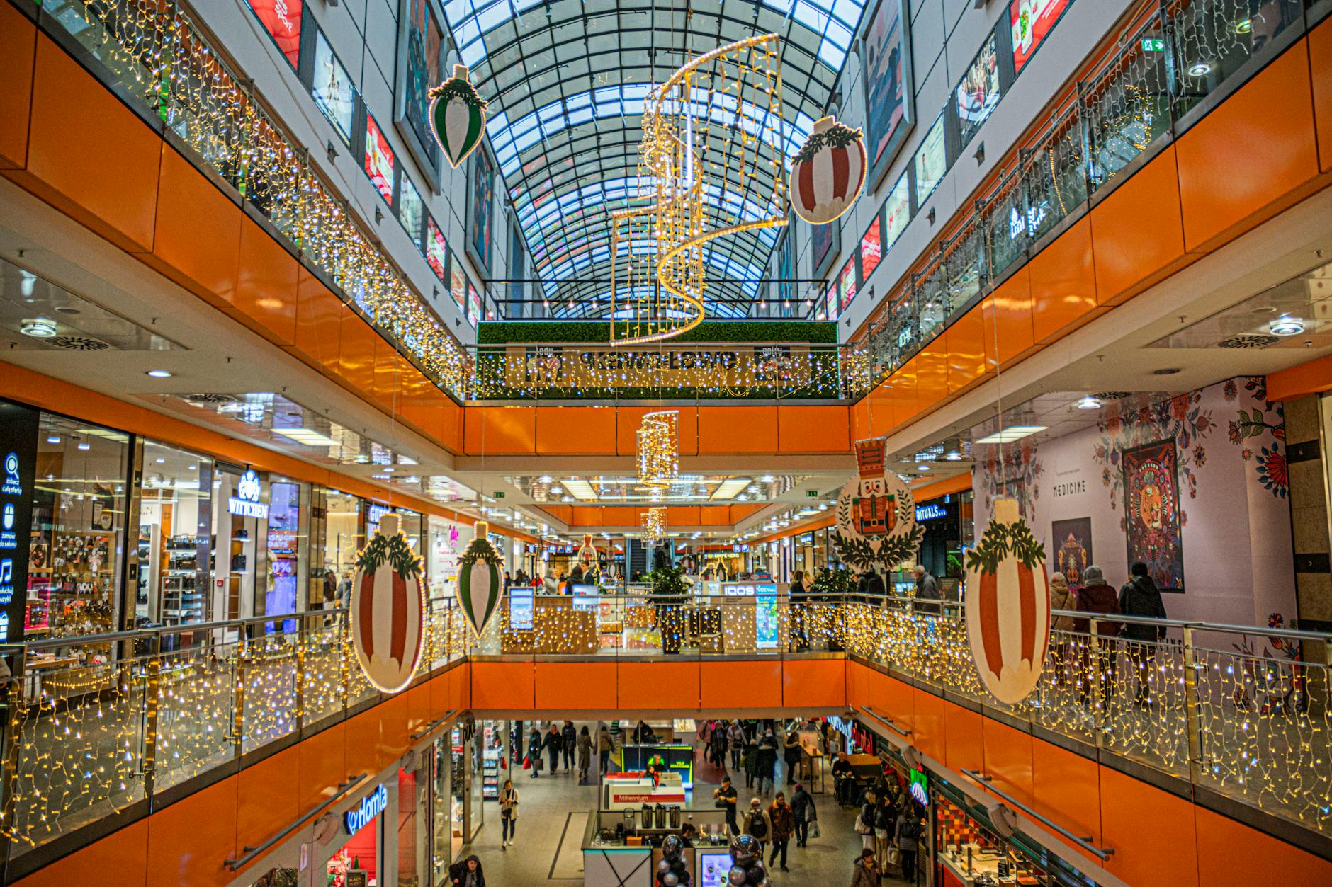 Interior view of modern shopping center with retail stores and consumers browsing