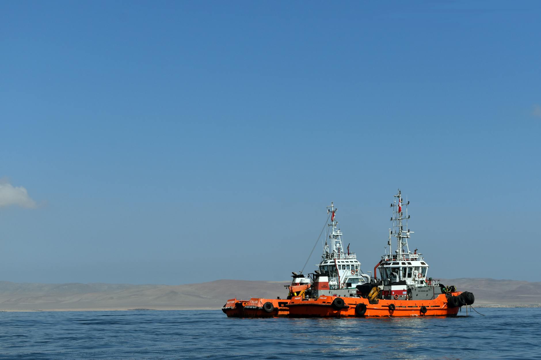Tugboat working alongside large vessel during maritime rescue operation