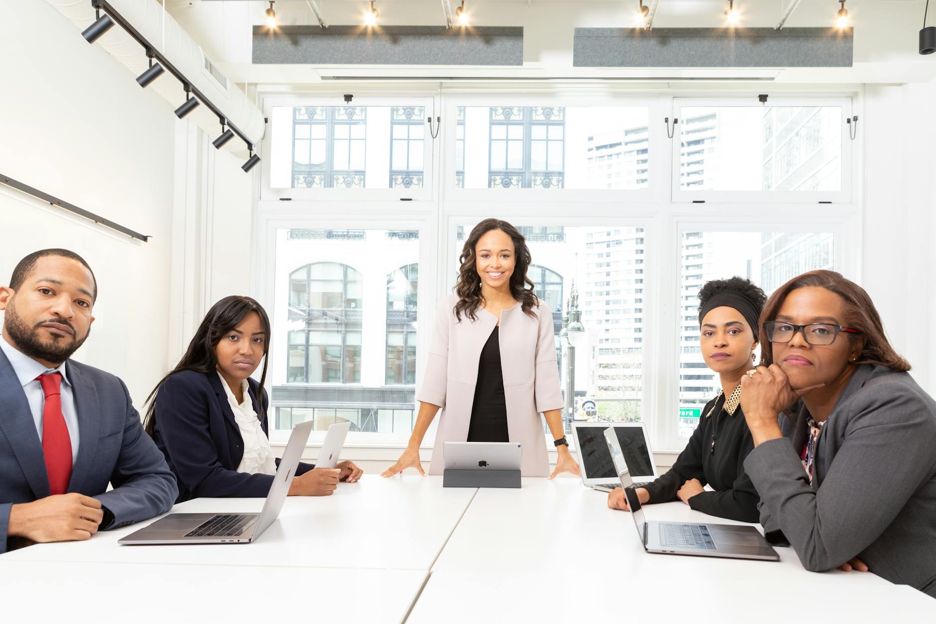 Professional business meeting scene with people in serious discussion around conference table