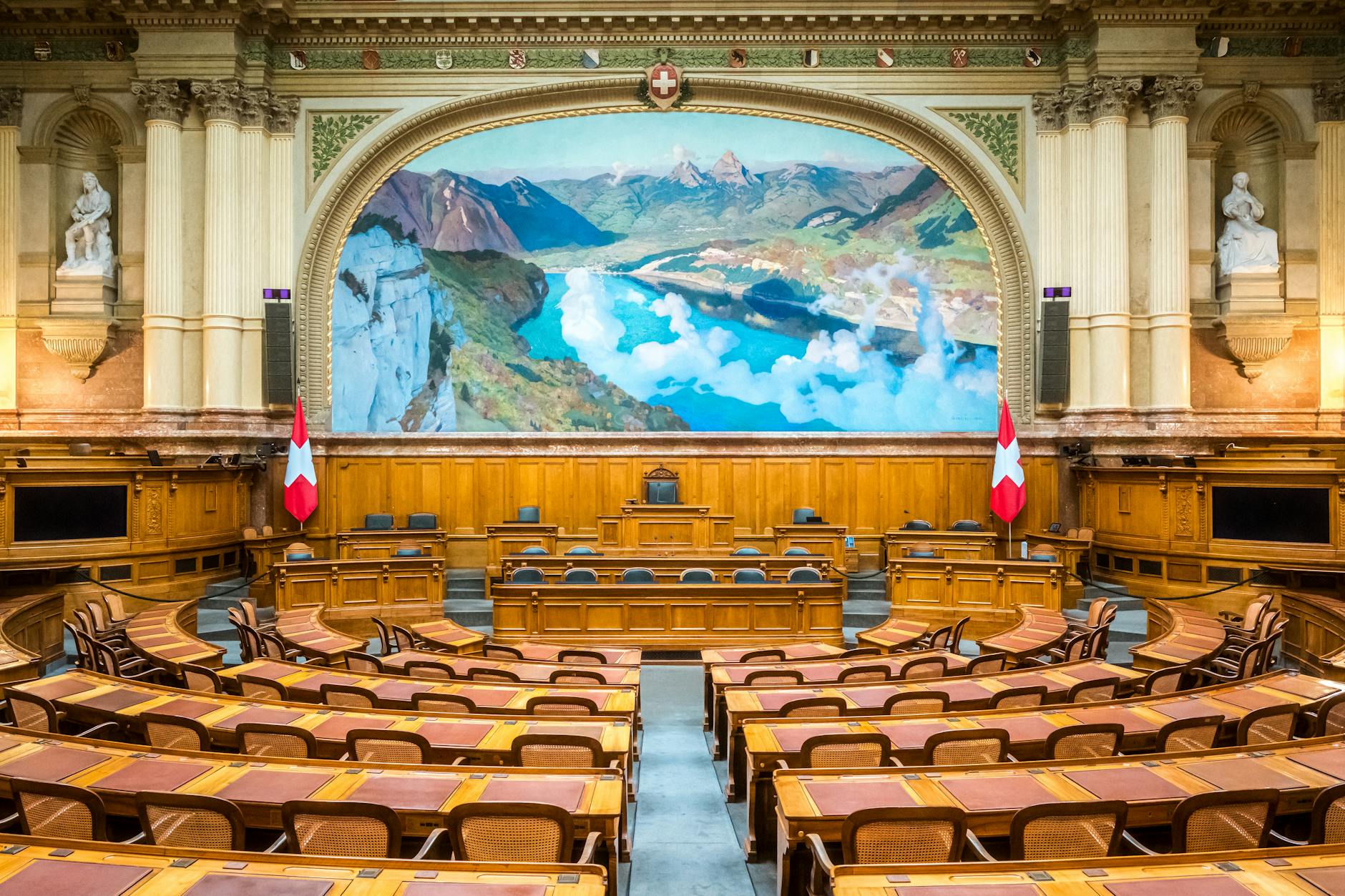 Interior of parliamentary chamber with rows of seats and formal government setting