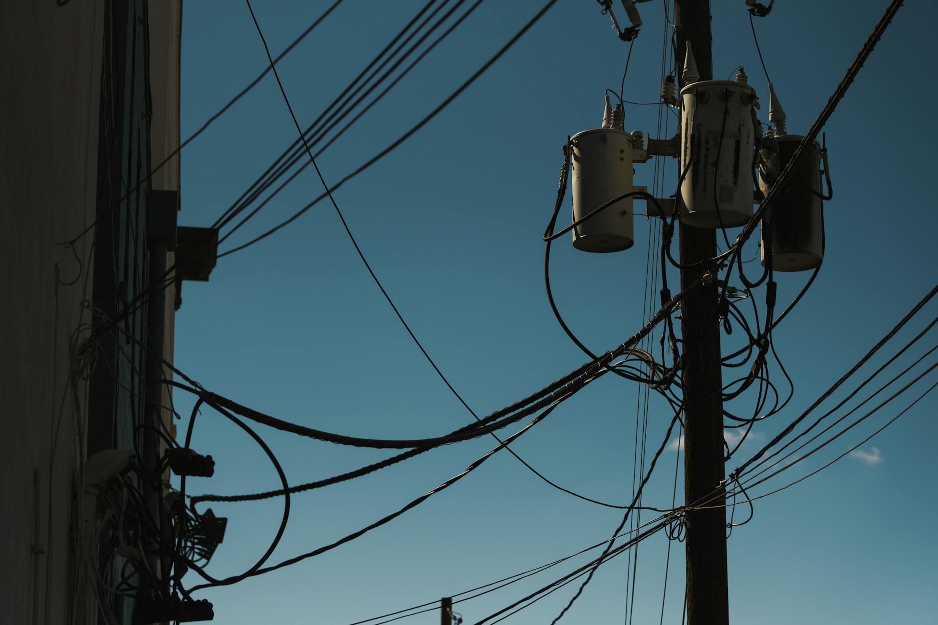 High-voltage electrical transmission lines and power grid infrastructure at sunset