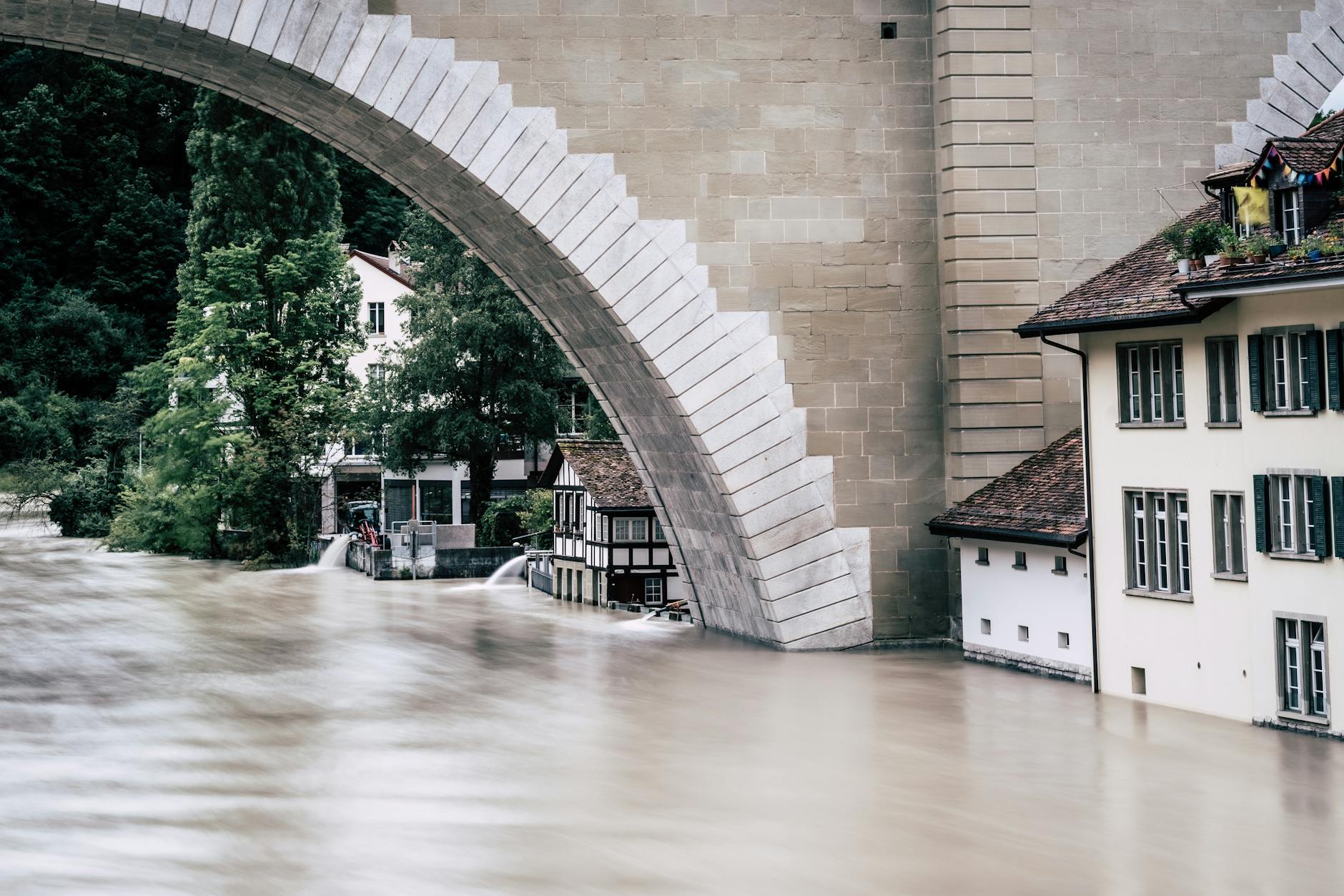 Historic stone bridge showing structural damage from severe flooding