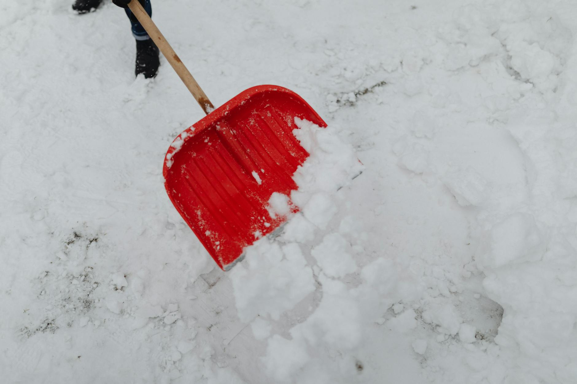 Heavy equipment clearing snow from transportation infrastructure during blizzard recovery efforts