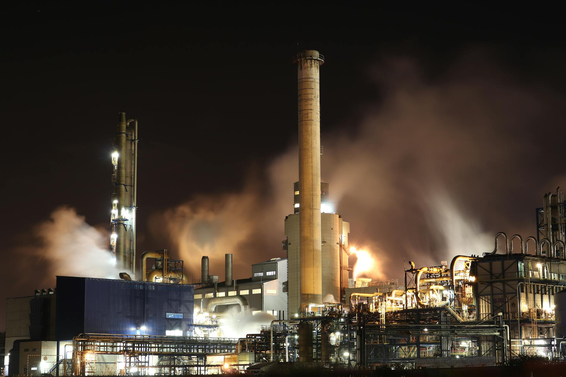 Modern oil refinery facility with processing towers and industrial equipment