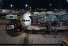 Cargo aircraft on airport tarmac with loading equipment nearby