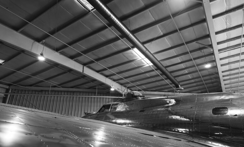 Workers on a commercial aircraft assembly line inside a large manufacturing facility