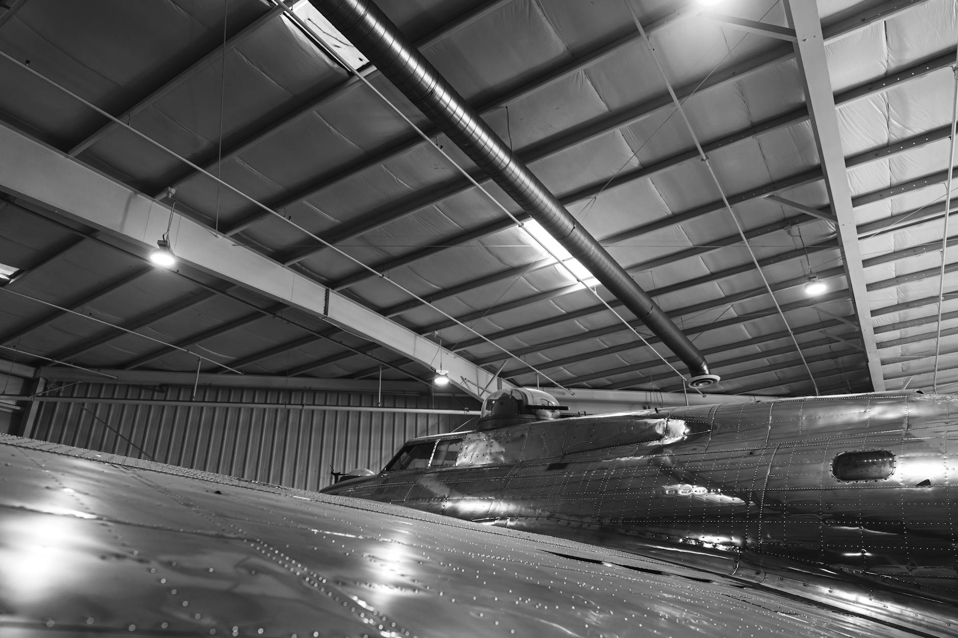 Workers on a commercial aircraft assembly line inside a large manufacturing facility
