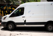 A delivery van driving through a busy city street representing same-day delivery logistics