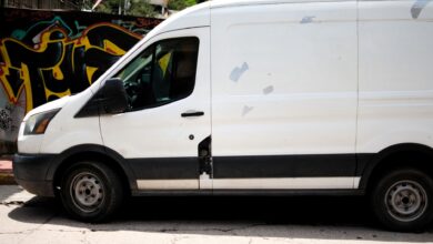 A delivery van driving through a busy city street representing same-day delivery logistics