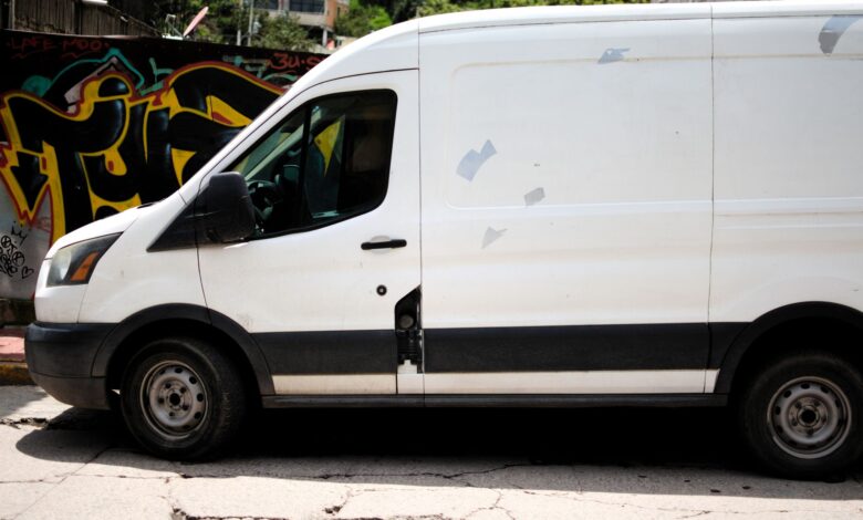 A delivery van driving through a busy city street representing same-day delivery logistics