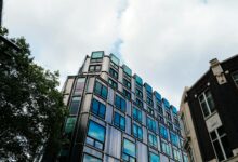 Glass office building exterior reflecting sky, representing commercial real estate vacancy concerns
