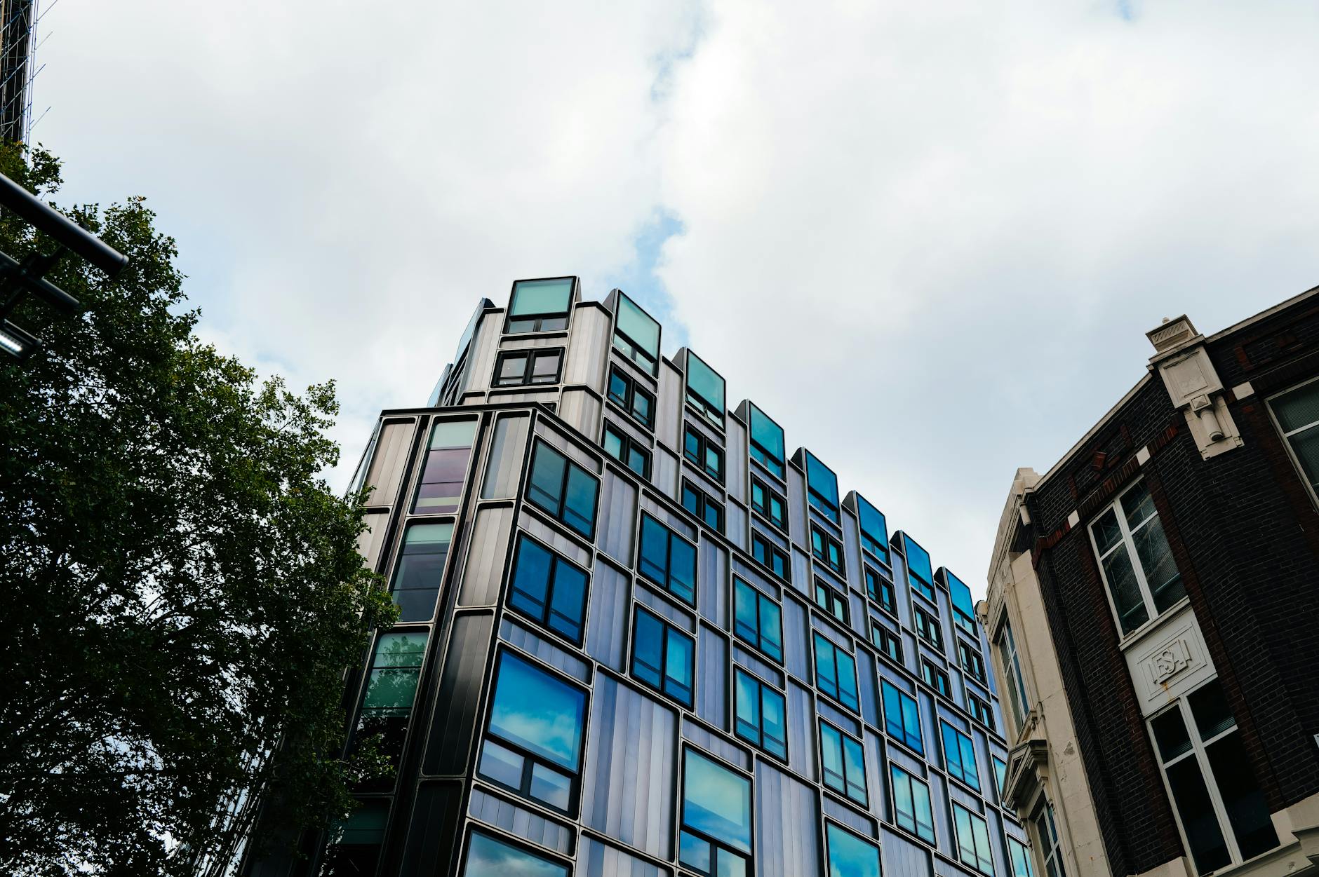 Glass office building exterior reflecting sky, representing commercial real estate vacancy concerns