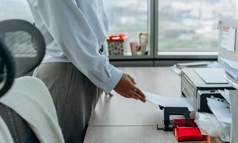 Corporate office workers using laptops and screens displaying software interfaces
