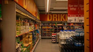 Wide grocery store aisle stocked with packaged food products and fresh produce