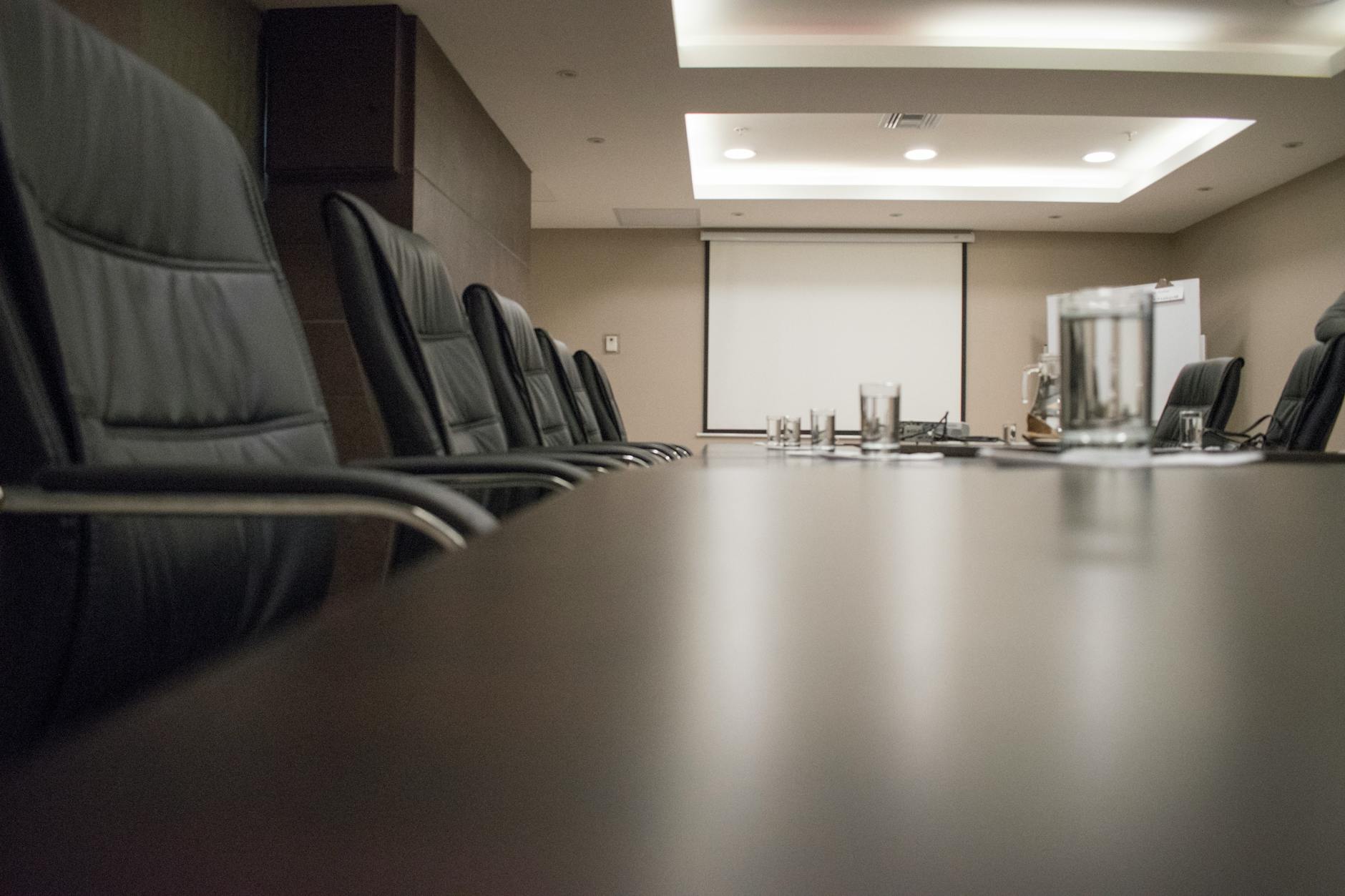 Modern corporate boardroom with conference table and chairs for executive meetings