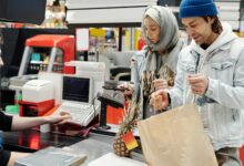 Modern retail checkout area with self-service kiosks and traditional cashier lanes