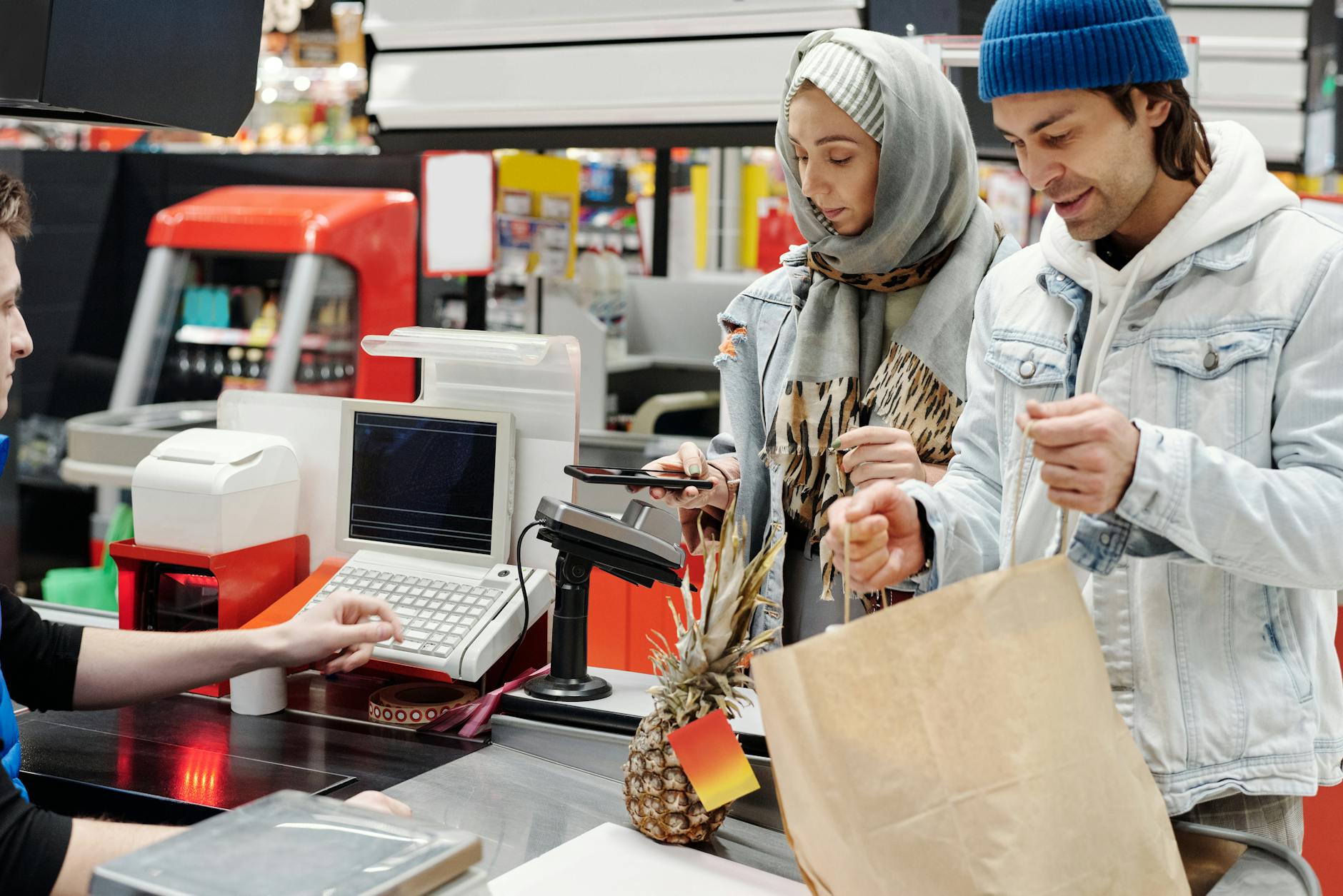Modern retail checkout area with self-service kiosks and traditional cashier lanes